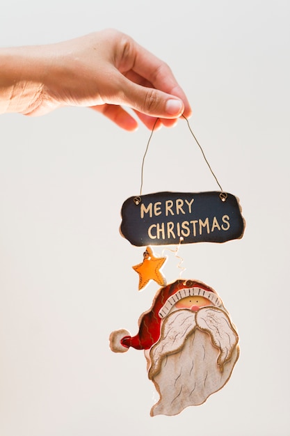 Free photo person holding toy with merry christmas inscription