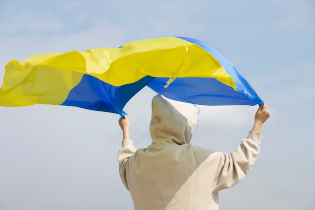 Free Photo person holding ukrainian flag