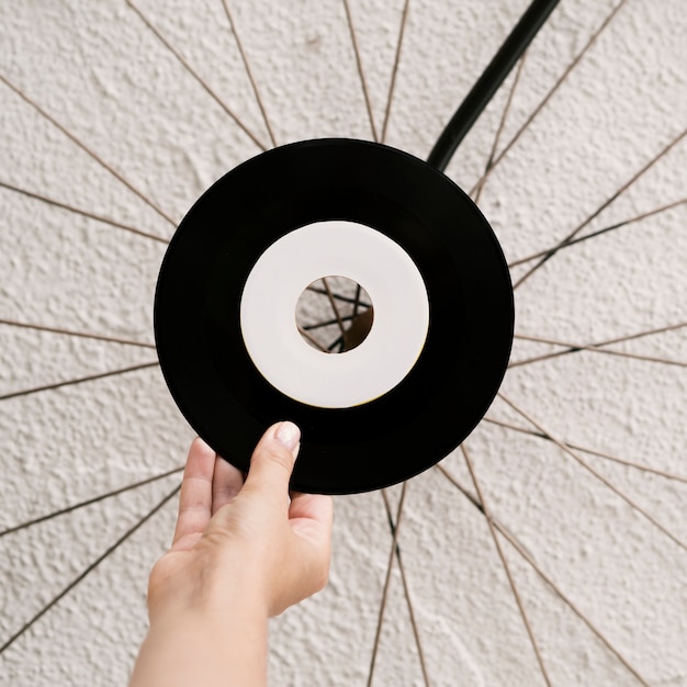 Free Photo person holding vinyl record near white wall