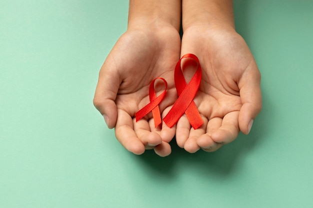 Person holding an world aids day red symbol