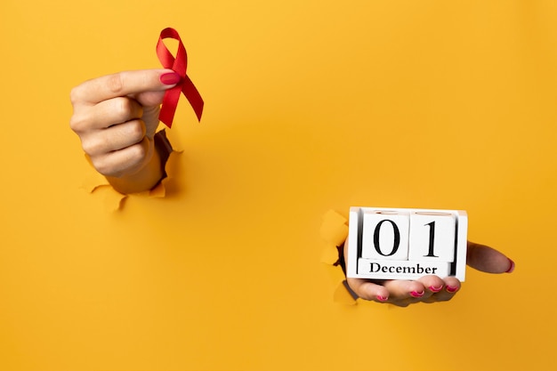 Free Photo person holding an world aids day ribbon symbol with the event date