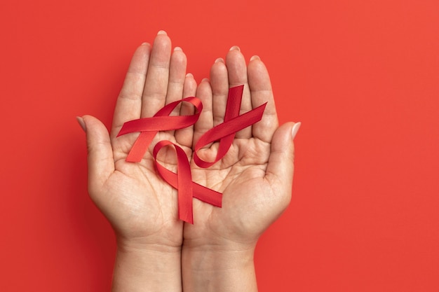 Person holding an world aids day ribbon symbol