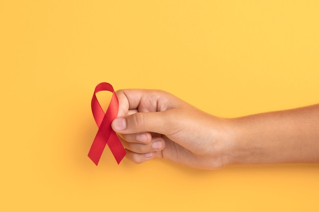 Free photo person holding an world aids day ribbon symbol