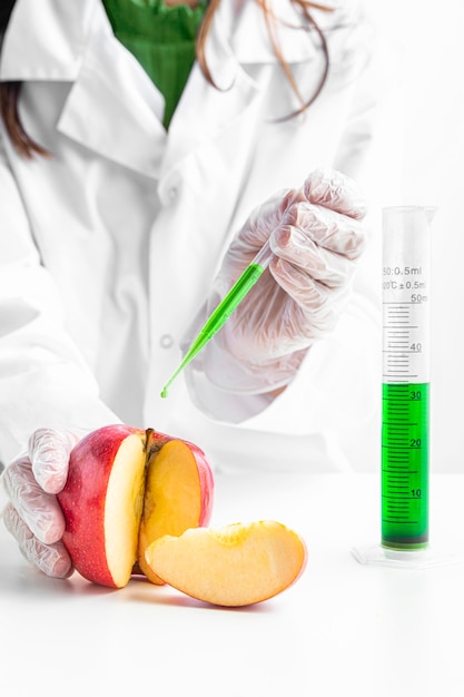 Person injecting an apple with green chemicals