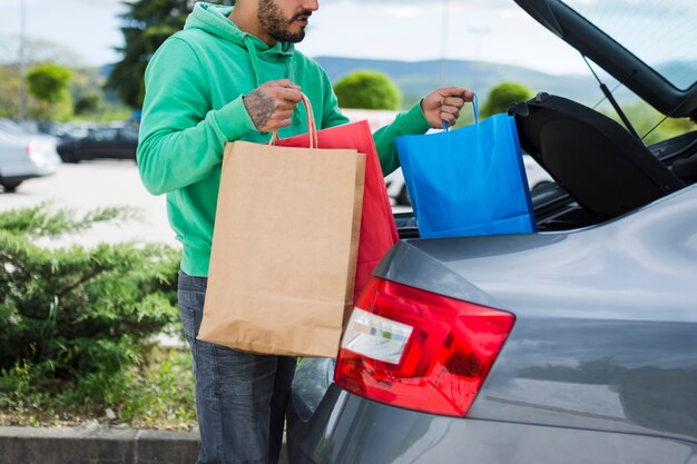 Person keeping shopping bags inside the car