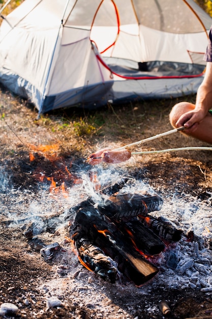 Free Photo person making sausages on fire grill