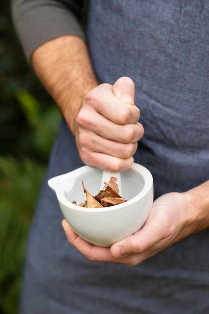 Person mixing herbs in the bowl