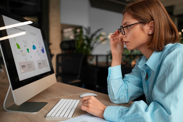 Free Photo person in the office analyzing and checking finance graphs