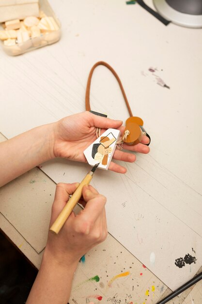 Person painting an abstract piece of wood