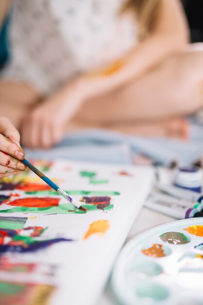 Person painting with gouache on light canvas