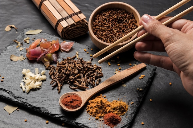 Free Photo person picking larvae with sticks close view