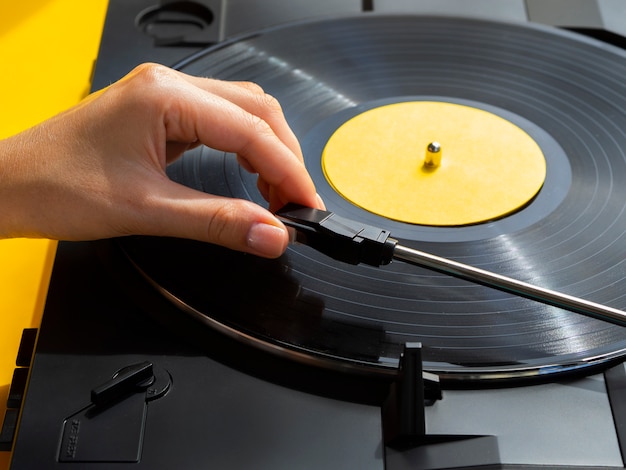 Free Photo person placing vinyl record in player