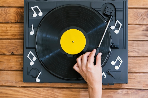 Person playing vinyl record in player