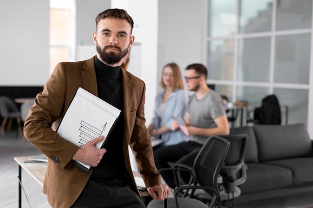 Free photo person posing next to coworkers