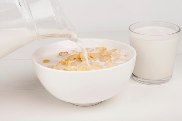 Person pouring milk in a bowl with milk