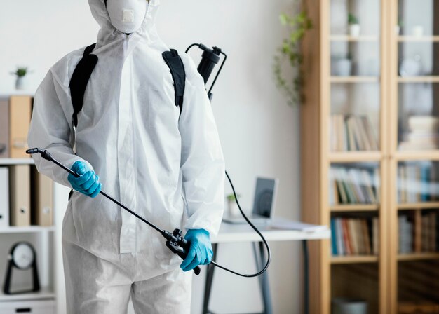 Person in protective equipment disinfecting