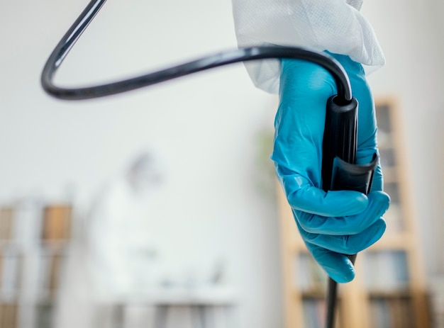 Free photo person in protective equipment disinfecting