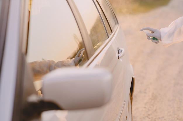 Free Photo person in a protective suit disinfect the car