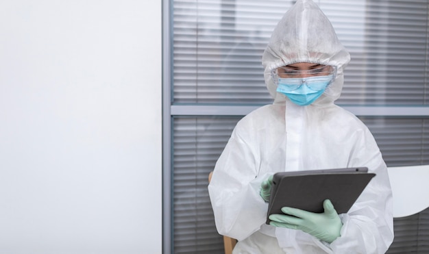 Person in protective suit looking at a tablet