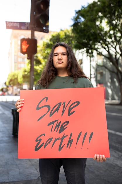 Free photo person protesting with placard for world environment day outdoors