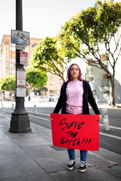 Person protesting with placard for world environment day outdoors