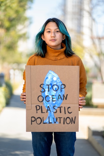 Person protesting with placard for world environment day outdoors