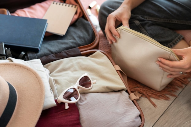 Free photo person putting clothes in a suitcase for her vacation