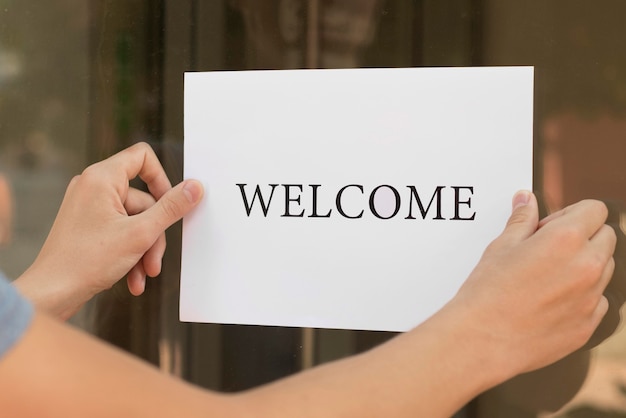 Person putting a welcome sign on a door