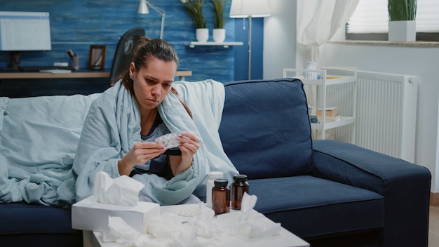 Free Photo person reading labels of capsule tablets and bottle with pills