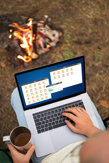 Free photo person remote working while in camping site