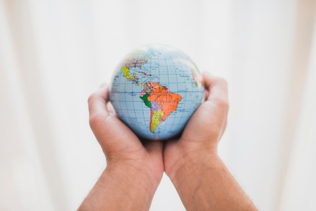 Free Photo a person's hand holding small globe