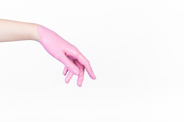 Person's hand painted with pink color on white backdrop