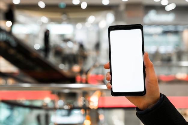 Free Photo a person's hand showing mobile phone screen display in the mall