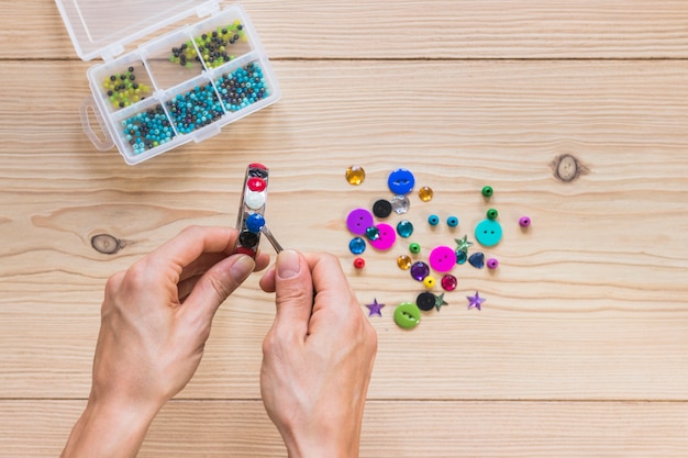 Free photo a person's hand sticking beads on metal bangle