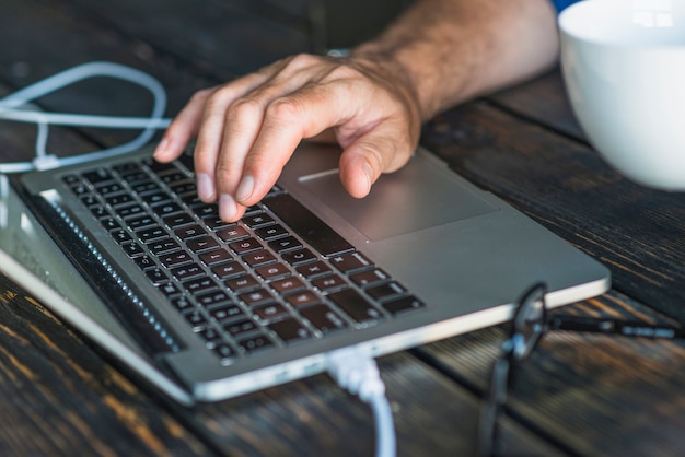 Free photo a person's hand typing on laptop keypad