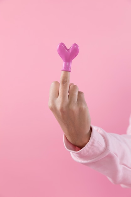 Free photo person showing middle finger with balloon in form of heart