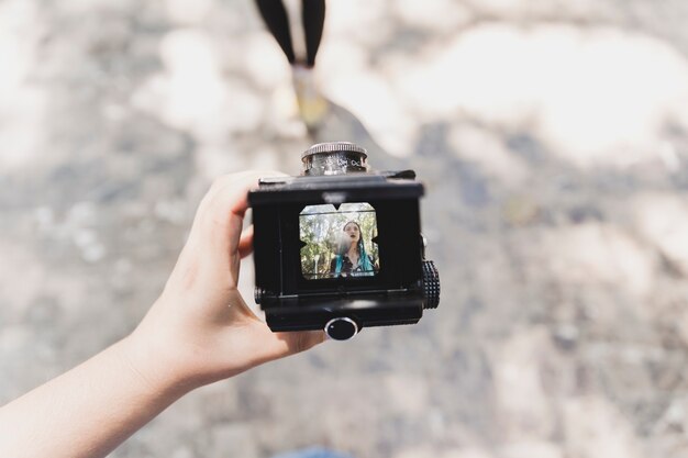 A person showing photo of a woman on vintage camera