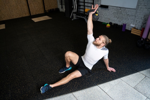 Person in sport gym using kettlebells