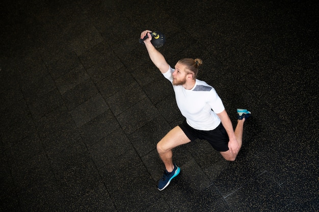 Person in sport gym using kettlebells