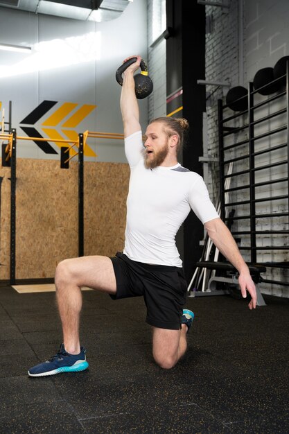 Person in sport gym using kettlebells