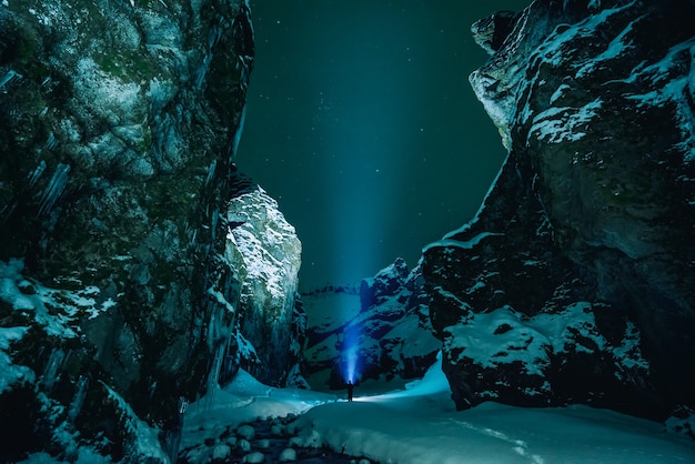 Free Photo person standing surrounded by snowy mountain