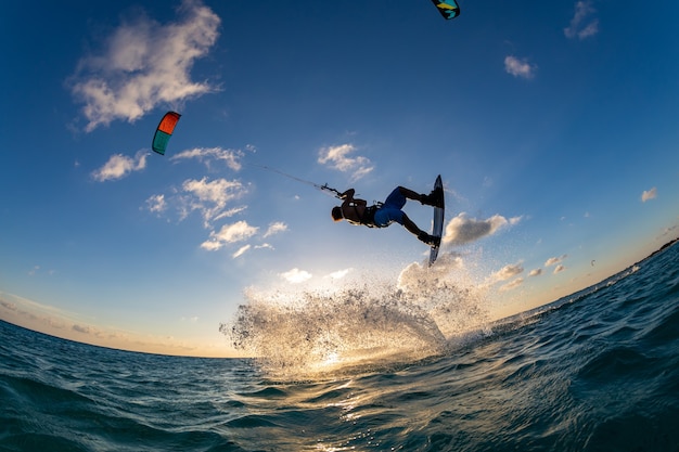 Free photo person surfing and flying a parachute at the same time in kitesurfing. bonaire, caribbean