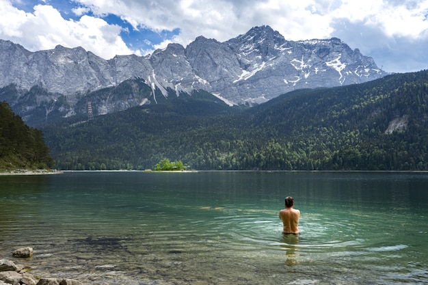 Person swimming in Eibsee lake in Germany in front of the mountains