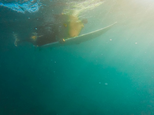 Free photo person swimming on surfboard in ocean