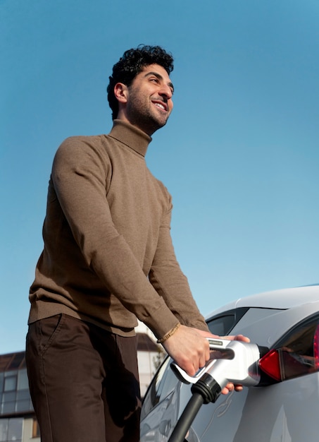 Free Photo person taking care of electric car