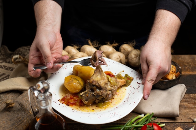 Free photo person taking meat from stew plate