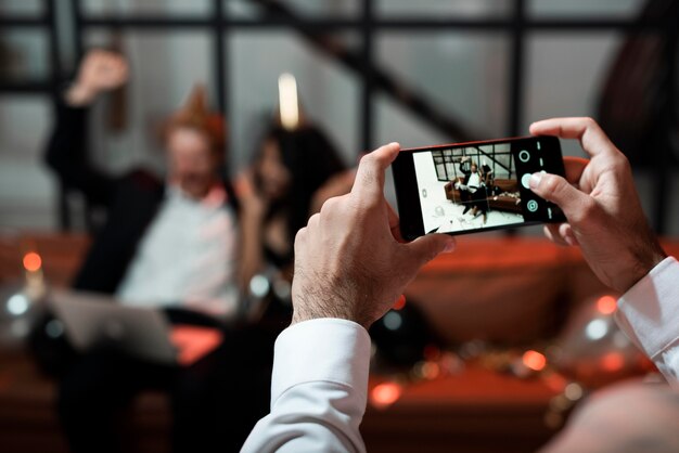 Free photo person taking a photo of his friends at new year's eve party