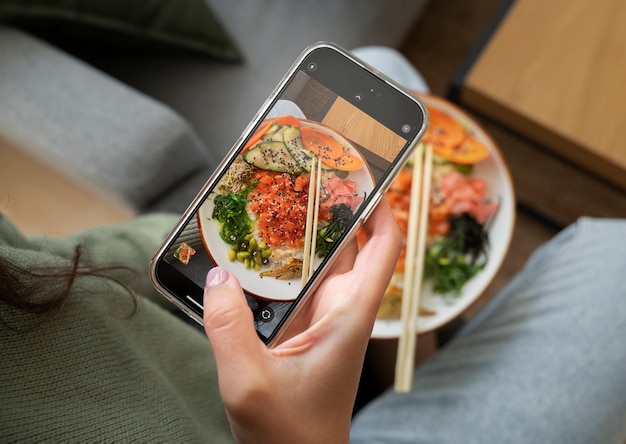 Free photo person taking photo of seafood dish with salmon