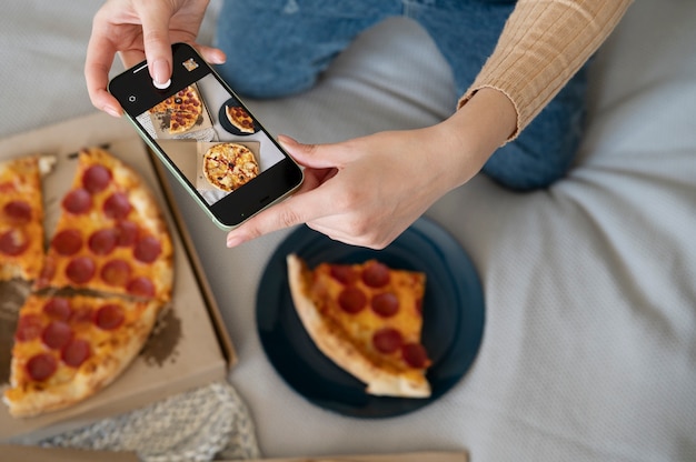 Person taking picture of pepperoni pizza