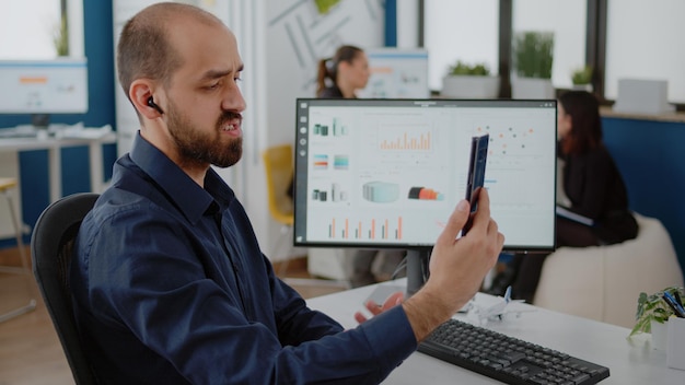 Free Photo person talking to colleagues on video call communication, using smartphone for business meeting. businessman holding mobile phone for online conference with workmates in corporate office